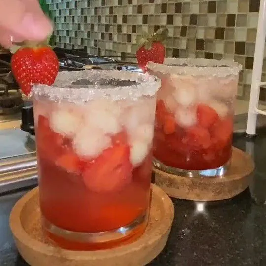 Beri hiasan strawberry dan Melon Berry Mocktail siap disajikan.