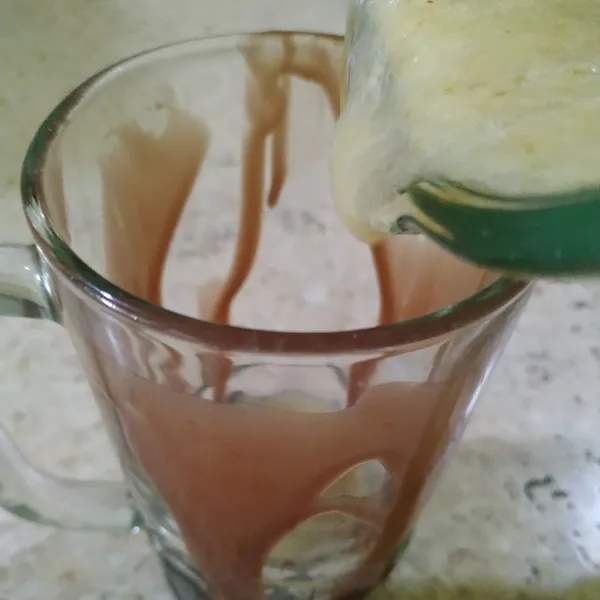 Tuang kental manis cokelat di badan gelas bagian dalam, lalu tuang jus belimbing bintangnya. Sajikan.