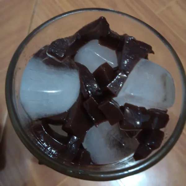 Dalam gelas masukkan es batu dan potongan jelly.