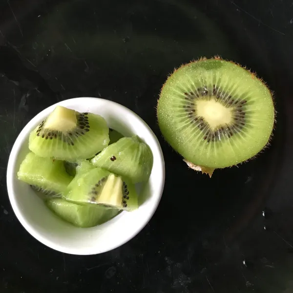 Potong buah kiwi menjadi beberapa bagian.