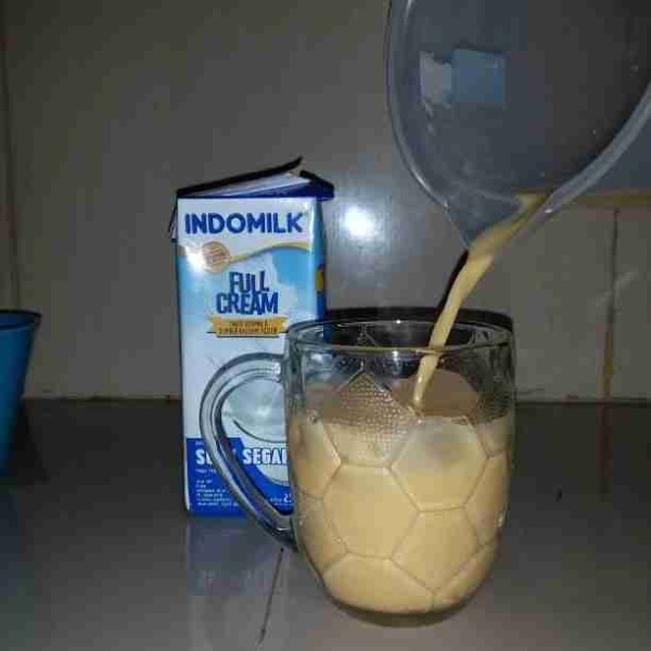 Tuang Es jeruk yakult ke dalam gelas saji.