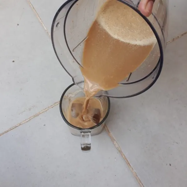 Tuangkan hasil blender air, kopi dan biskuit kedalam gelas yang berisi es batu.