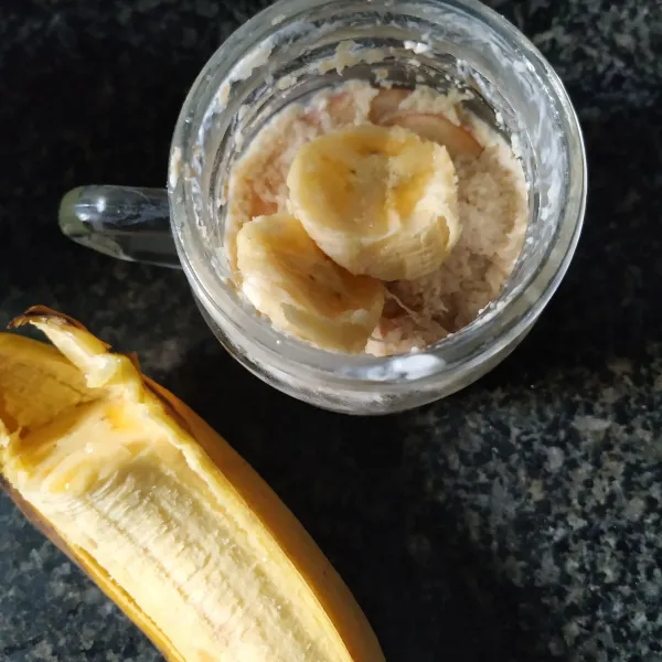 Beri 3 sdm quaker ditata atasnya diberi potongan pisang dan yougurt atasnya diberi buah jeruk.