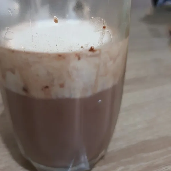 Seduh minuman cokelat dengan sedikit air panas, tambahkan air dan es sesuai selera, sajikan.