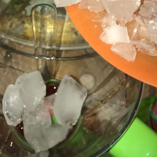 Tuang sirup marjan dan es batu ke dalam blender