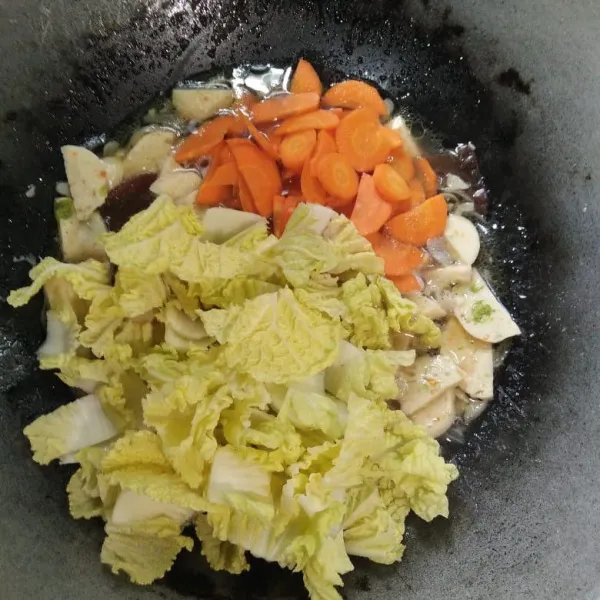 Masukan wortel masak hingga setengah matang lalu tambahkan sawi. Aduk rata.