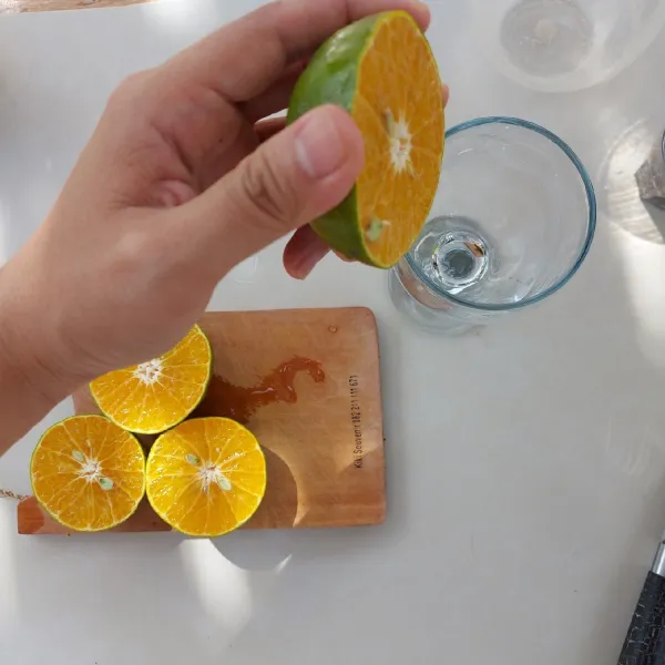 Potong dan peras jeruk.