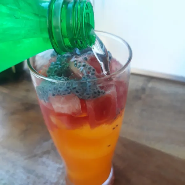 Tambahkan air soda hingga gelas penuh. Sajikan.