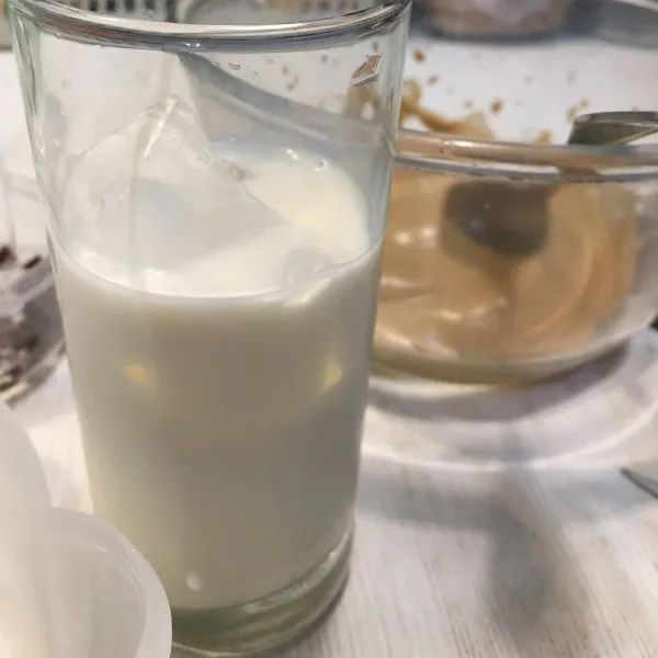 Tuang susu cair dan ice cube ke dalam gelas.