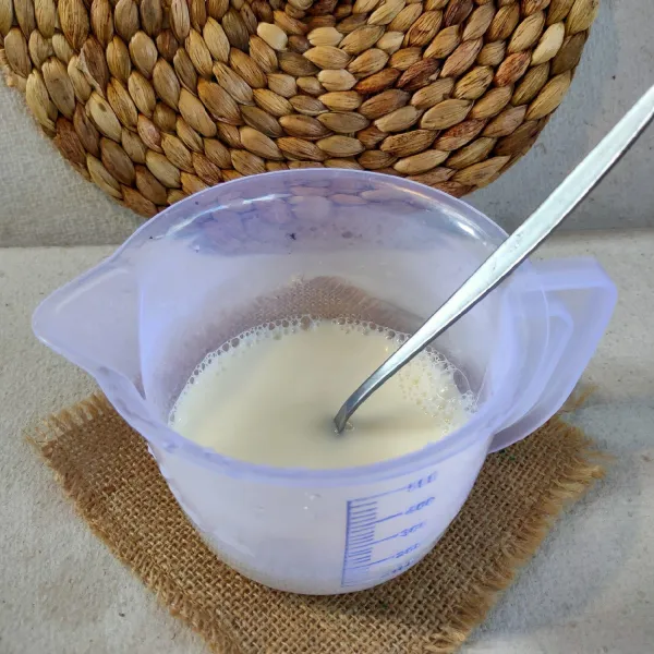 Larutkan kental manis dan air, aduk rata.