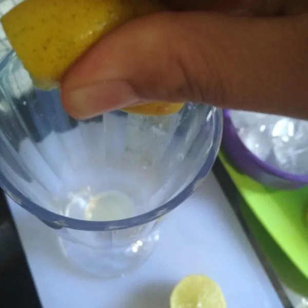 Siapkan gelas saji, peras jeruk nipis langsung ke gelas saji.