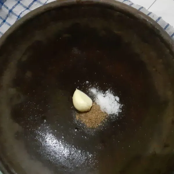 Siapkan 1 siung bawang putih, garam dan ketumbar bubuk secukupnya. Lalu haluskan semua bumbu.