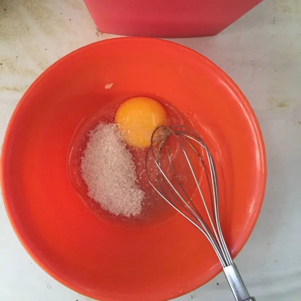Kocok telur dengan gula pasir sampai tercampur rata.