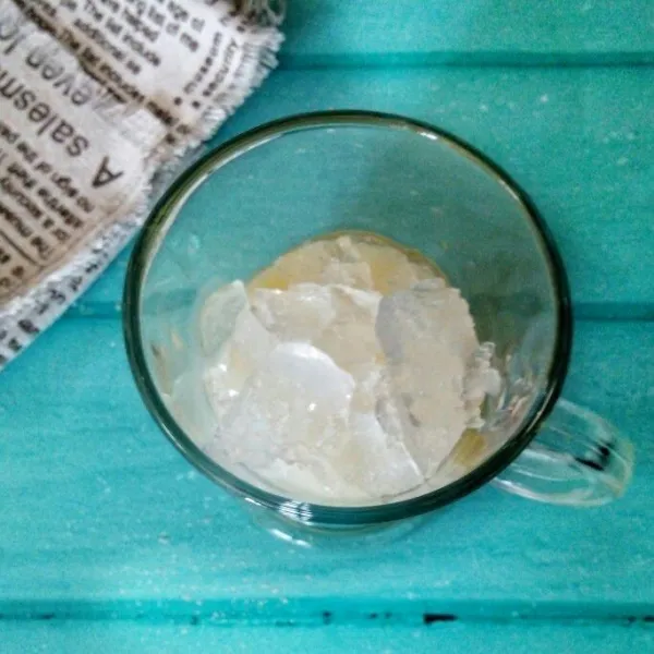 Tuang krimer kental manis dalam gelas, kemudian tambahkan es batu secukupnya.