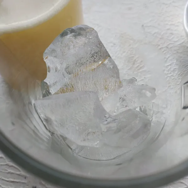 Dalam gelas masukkan es batu.