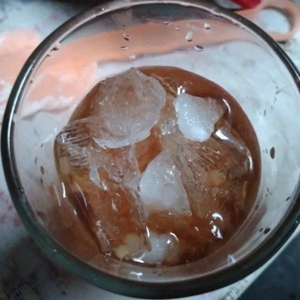 Masukkan es batu kedalam gelas kemudian tuang air teh manis kemudian tuang 100 ml air rebusan serai
