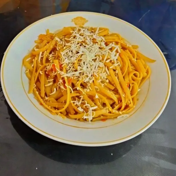 Spaghetti goreng siap di sajikan dengan keju parut.