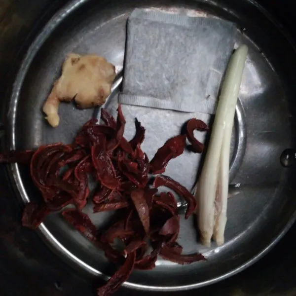 Letakkan kulit manggis, serai, jahe dan teh dalam panci.