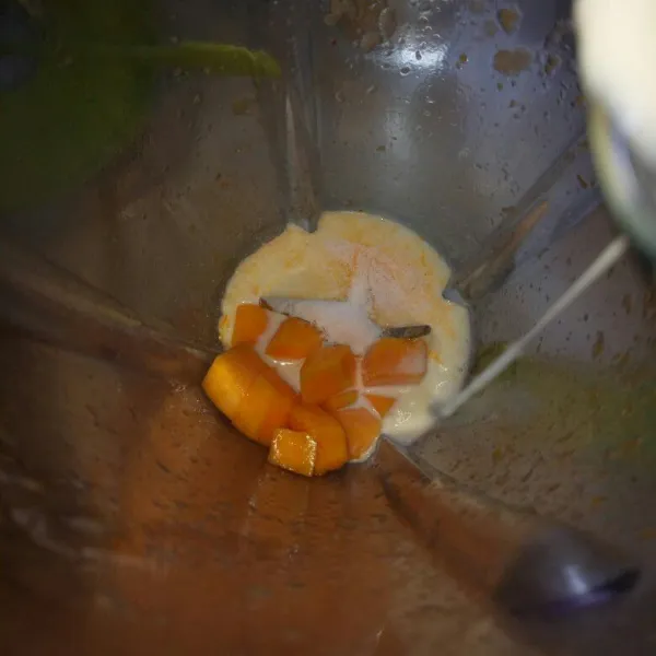 Blender jadi satu,sebagian buah mangga,pop ice mangga,susu full krim dan es batu.Blender sampai halus dan tercampur rata.