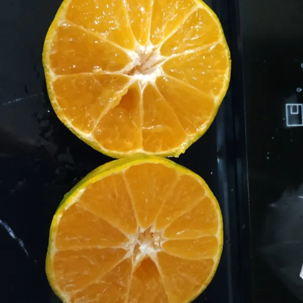 Potong jeruk menjadi 2 bagian.