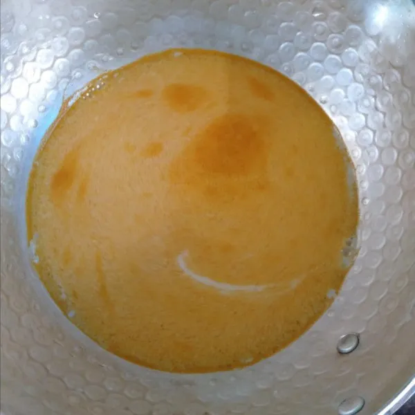Dalam panci, larutkan kunyit bubuk bersama susu cair.