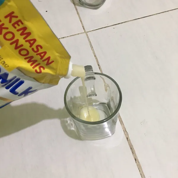 Tuangkan susu kental manis.