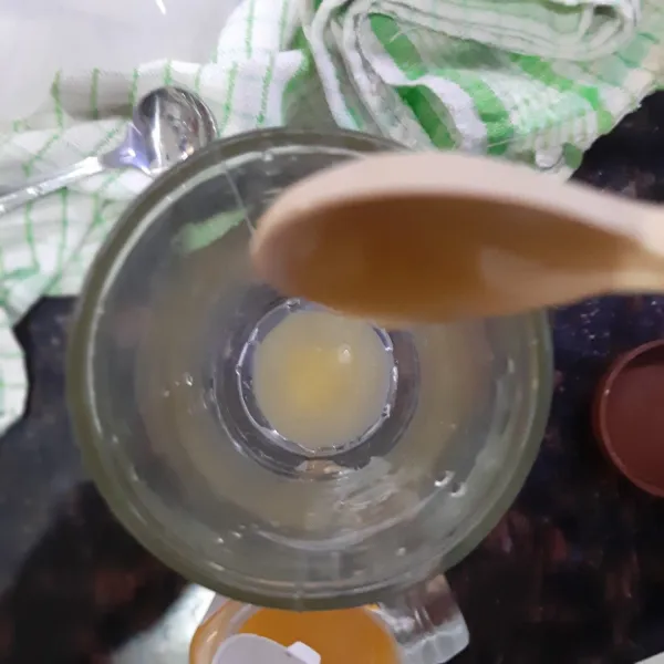 Tuang madu ke dalam gelas, tambahkan es batu jika suka.