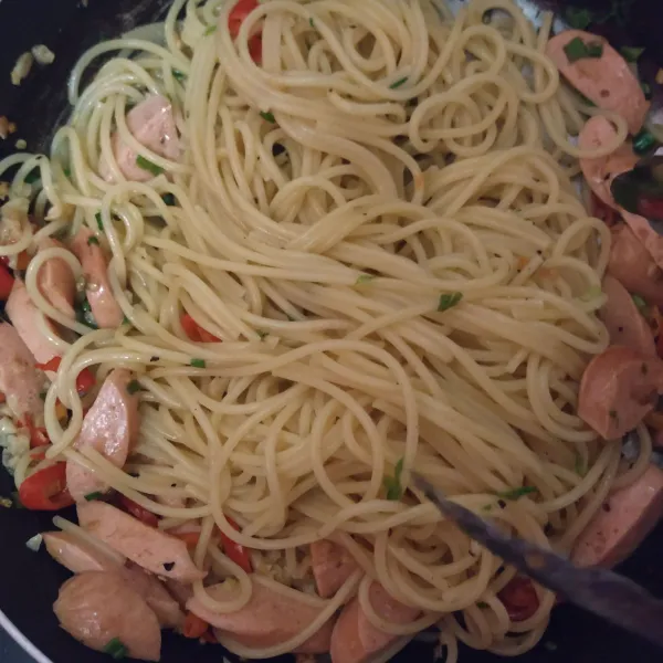 Masukkan sosis, spaghetti, daun bawang, garam, bubuk cabe, blackpapper dan parsley.