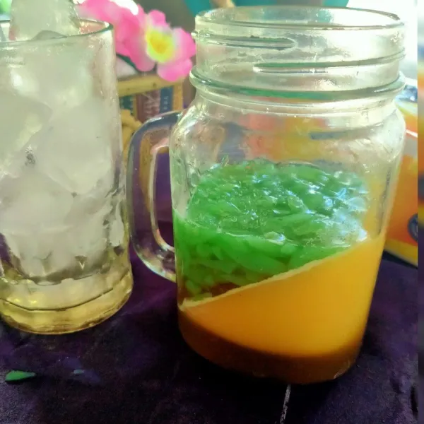 Setelah pudding mangga mengeras, lalu masukkan cendol hijau, lalu gula Jawa cair.