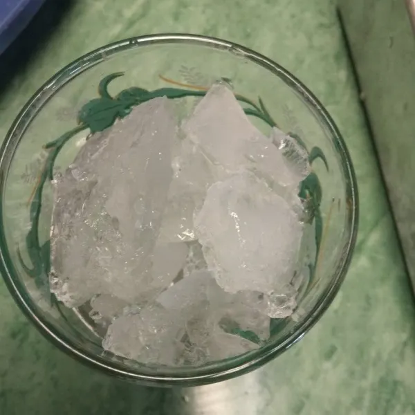 Siapkan es batu, masukkan dalam gelas.