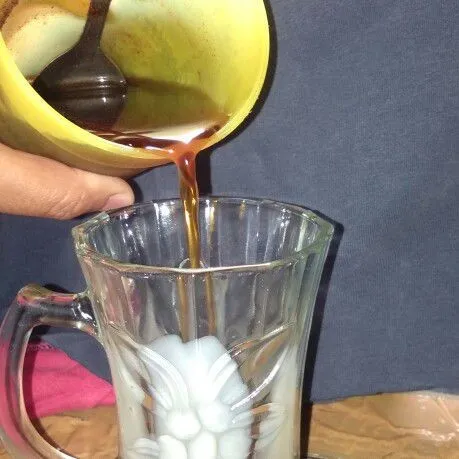 Tuang kopi yang sudah didiamkan di kulkas dalam gelas susu.