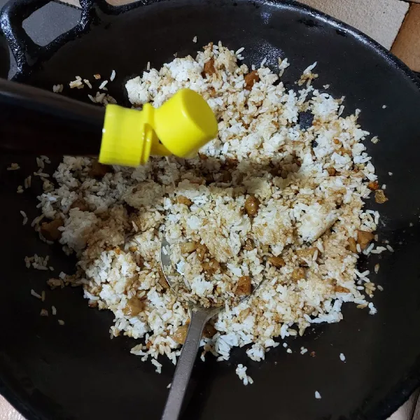 Masukkan nasi putih aduk dan tambahkan minyak wijen.