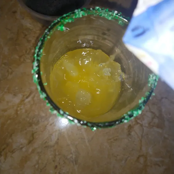 Tuangkan jus mangga, pelan pelan agar berlayer