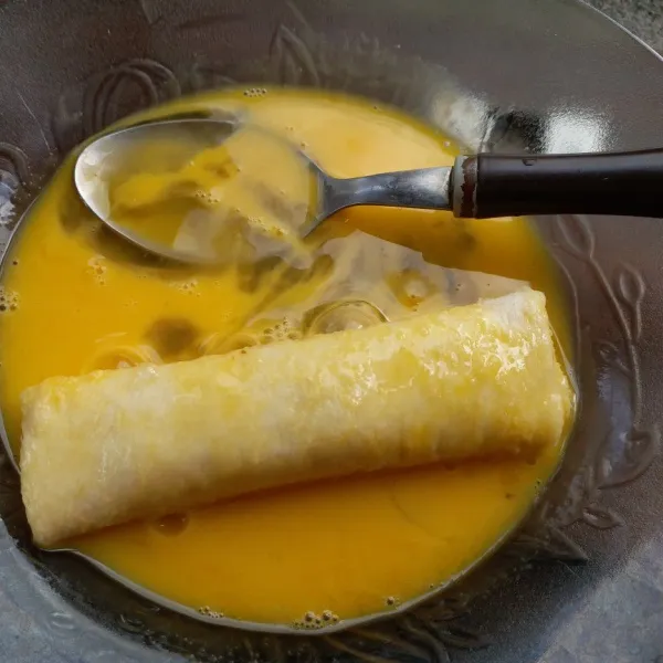 Celupkan gulungan roti ke kocokan telur.