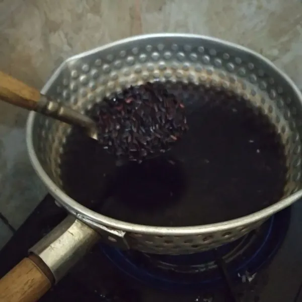 Didihkan air. masukkan ketan hitam, masak hingga matang.