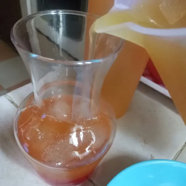 Tuangkan campuran jus ke gelas. Pelan-pelan supaya tidak langsung tercampur.