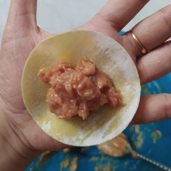 Letakkan kulit dimsum di telapak tangan, ambil 1sdm adonan daging diatasnya. Teluk jari² tangan sehingga pinggiran kulit dimsum menyerupai mangkuk.