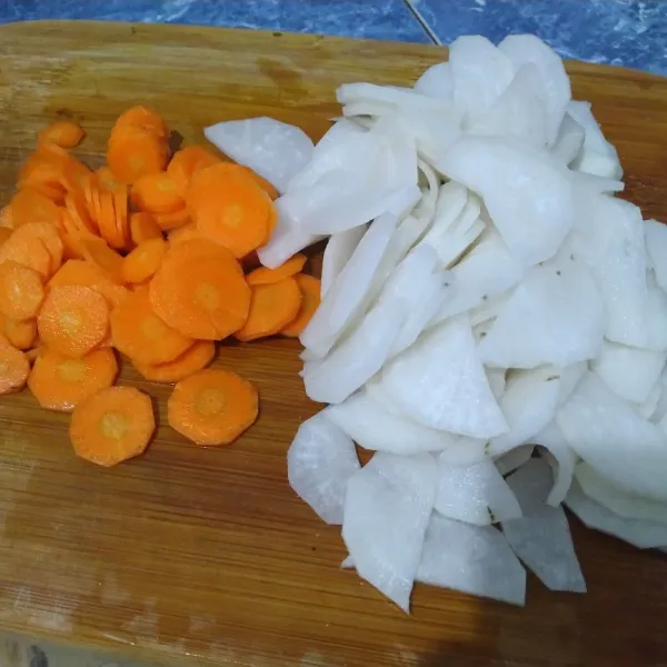 Cuci bersih lobak dan wortel kemudian iris tipis.