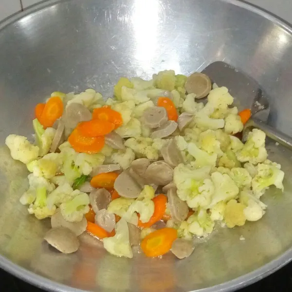 Masukkan kembang kol, wortel dan bakso aduk rata masak sampai sayuran hampir matang.