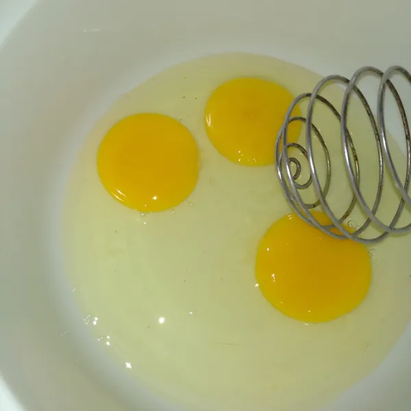 Masukkan telur dalam wadah, kemudian kocok menggunakan whisk sampai berwarna kuning keputihan.