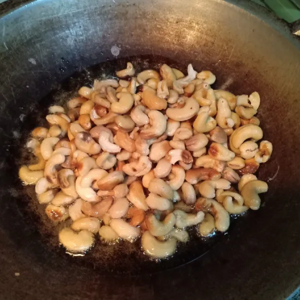 Panaskan minyak lalu goreng dengan api sedang sambil terus diaduk agar panas merata hingga kacang juga matang merata.