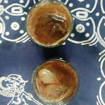 Tuang kopi jahe dalam gelas kemudian tuang perlahan coklat sambil diaduk, tambahkan es batu dan beri irisan jahe, siap disajikan.