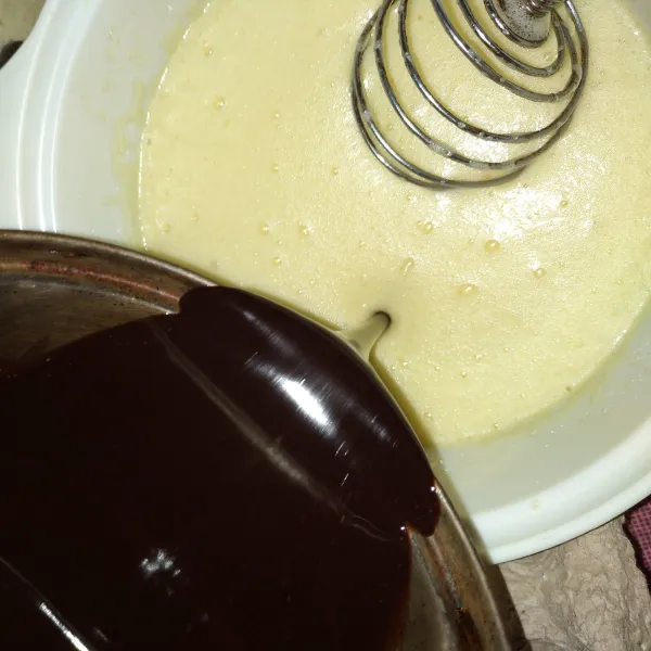 Masukkan cokelat dan margarine yang sudah di lelehkan (pastikan cokelat sudah dingin agar telur tidak matang). Kemudian aduk sampai rata.