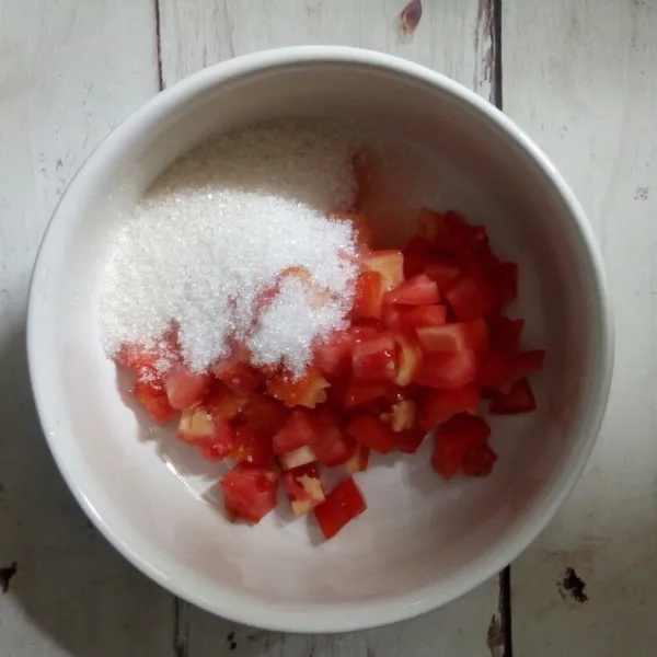 Siapkan mangkuk, campur tomat dengan gula pasir.