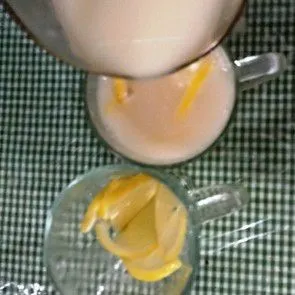 Tata lemon dan es batu dalam gelas, tuang sari bengkoang.