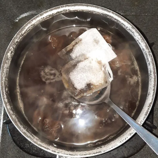 Masukkan teh celup dan air perasan jeruk nipis, diamkan hingga hangat