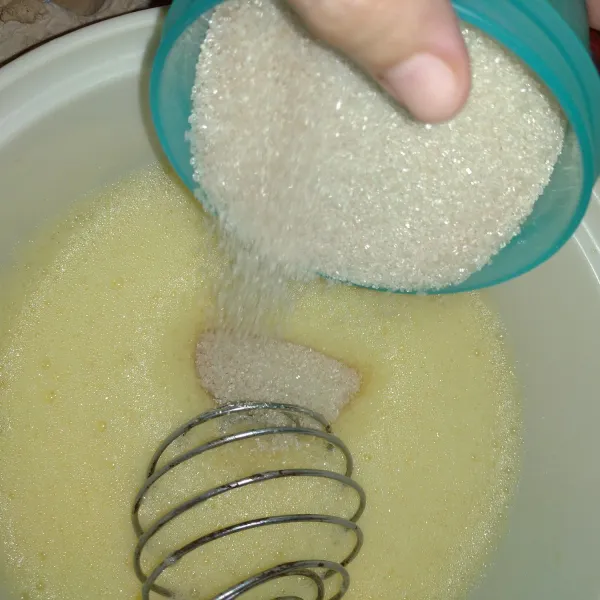 Setelah mengembang, masukkan gula secara bertahap aduk sampai rata. Kemudian masukkan sisa gulanya dan aduk kembali sampai tercampur.