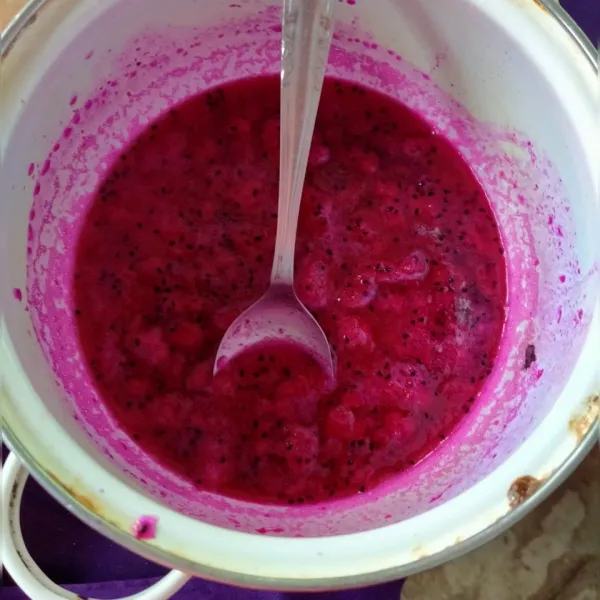 Potongan buah naga dicampur dengan gula cair. Lalu diaduk-aduk. Kemudian tuangkan di gelas saji.