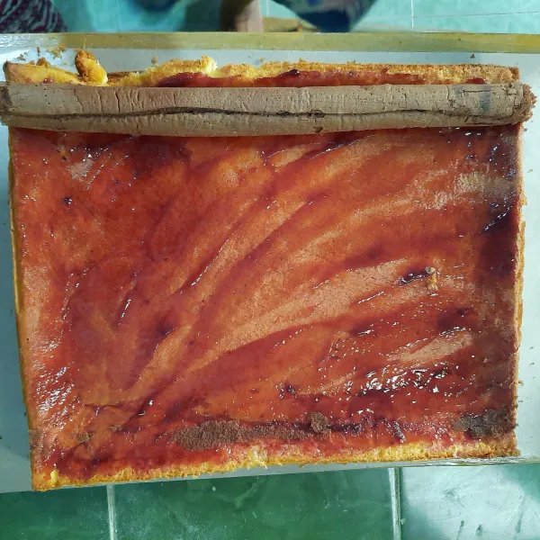 Setelah matang dan dingin beri selai blue berry dan letakkan diatasnya gulungan bolu cokelat.