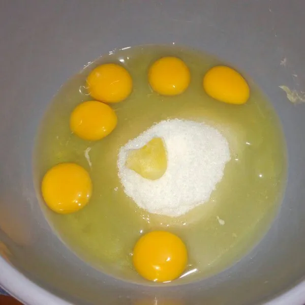 Di wadah lain campur telur, gula pasir dan SP. Mixer dengan kecepatan tinggi selama 10 menit sampai mengembang putih dan berjejak.